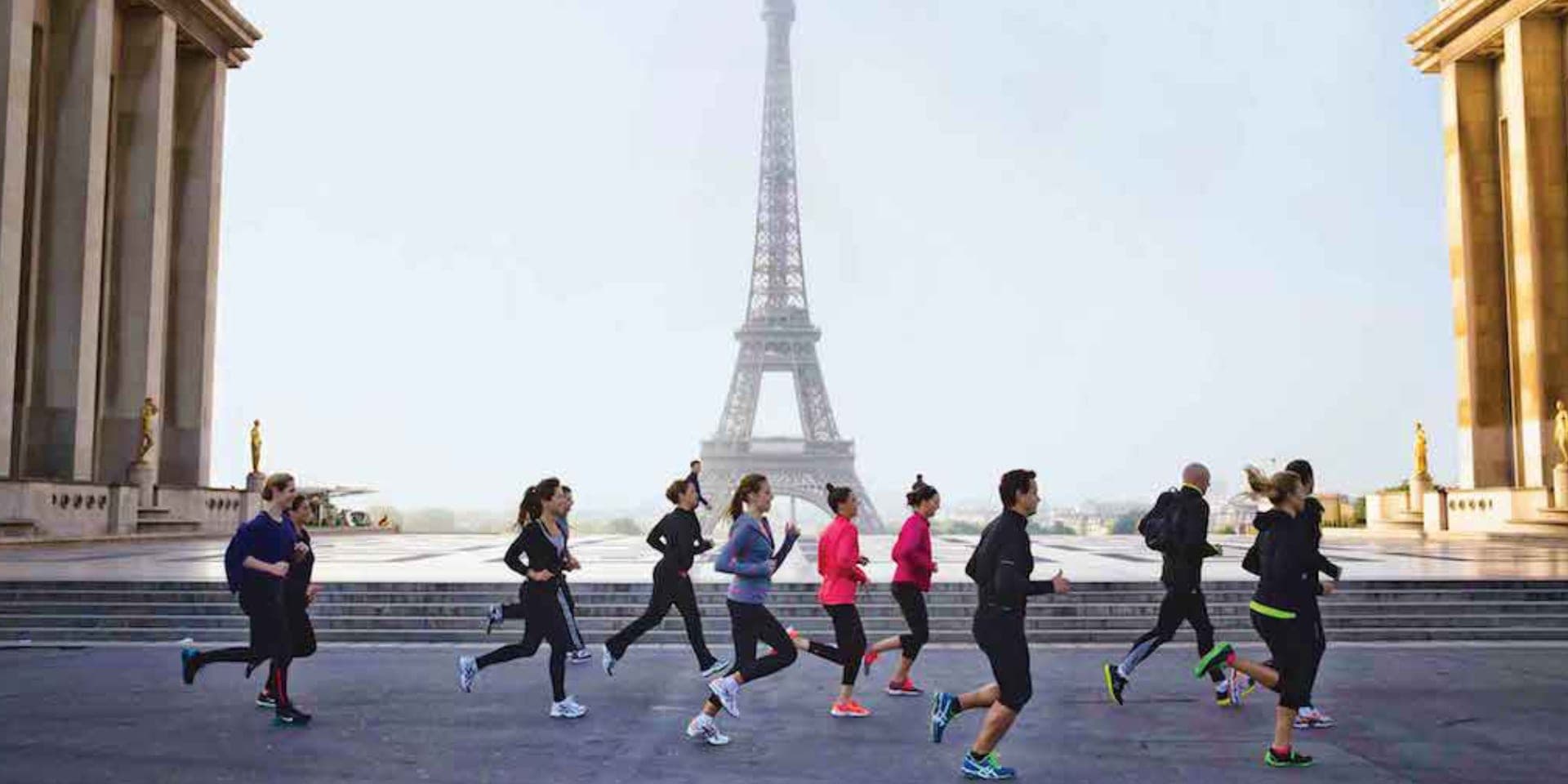 Un gruppo di runner che corre insieme attraverso il Trocadéro a Parigi, con la Torre Eiffel sullo sfondo